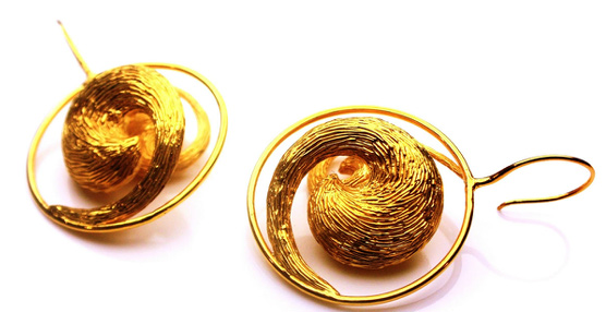 Pendientes de oro en forma de torbellino con unas curvaturas dramáticas que recuerdan al Monzón indio.