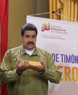 El presidente venezolano posa con un lingote de oro durante el anuncio de su Plan Oro. 